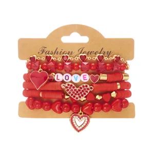 Detail van rode heishi kralen armbandenset met hartbedeltjes en LOVE-kralen