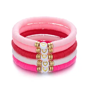 Detailopname van roze en rode polymeerklei kralenarmbandset met gouden hart