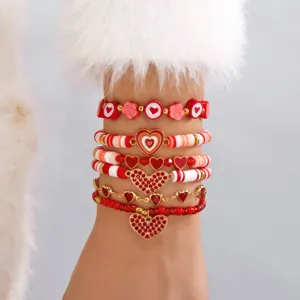 Detailweergave van een 6-delige rode armbandenset met hart en bloemen