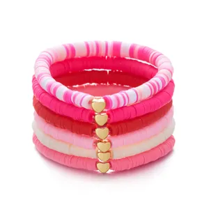 Close-up van roze kleikralen armbanden set met gouden hartjes voor Valentijnsdag