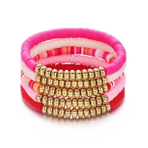 Set van gestapelde Valentijnsdag-armbanden met roze Heishi-kralen en gouden details