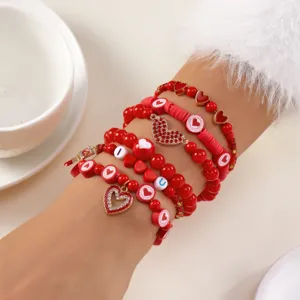 Detailopname van rode polymeerklei armbanden met hartjes en glinsterende bedeltjes