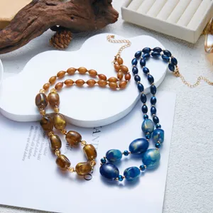 Dettaglio di collane in resina marrone tartarugata e blu con perle di forma irregolare