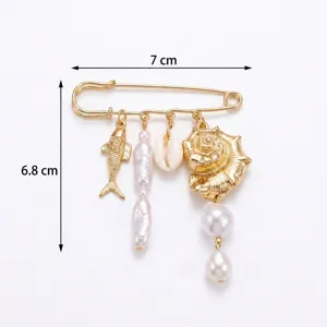 Detailed macro shot of gold safety pin brooch with ocean shell and pearl charms