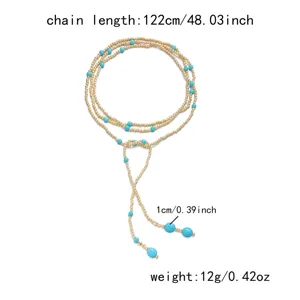 Macro view of long multi-layer Y-shaped tassel necklace with turquoise and gold beads