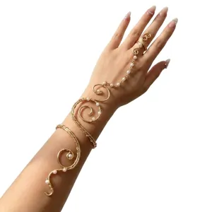 Élégant bracelet de bras doré avec perles et bague intégrée sur le bras du modèle