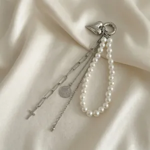 Dettaglio della catena per borsa con ciondolo a cuore, perle sintetiche e nappe metalliche