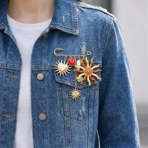 Close-up of a vintage sun and heart charm brooch styled on a blue denim jacket.