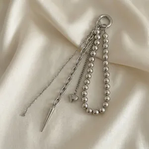 Dettaglio di ciondolo per borsa argento multifilo con cuore e perle metalliche