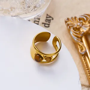 Detail of vintage gold stainless steel ring with tiger eye stones and adjustable open band.