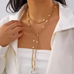 Close-up of elegant Y-shaped multi-layer necklace with gold beads and pearls on a model