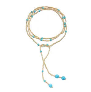 Detailed close-up of a multi-layer Y-shaped necklace with gold beads and turquoise stones.