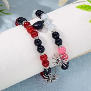 Nahaufnahme von Halloween Magnet-Armbändern für Paare mit Spinnen-Anhängern und Herz-Magnet