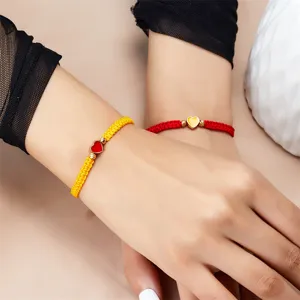 Macroweergave van het weefpatroon en de hartvormige bedel op kleurrijke armbanden