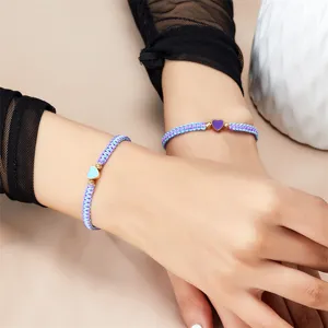 Detailopname van handgeweven koppelarmbanden met kleurrijke geëmailleerde hartjes
