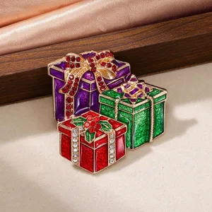Détail d'une broche de Noël festive avec des boîtes cadeaux colorées en strass dorés
