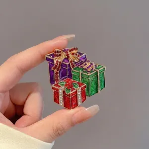 Détail d'une broche en émail en forme de boîte cadeau de Noël avec des strass brillants