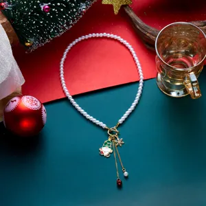 Dettaglio del collier di perle natalizie con ciondolo di Babbo Natale e campanellino
