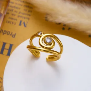 Nahaufnahme eines goldfarbenen Edelstahl-Spiralrings mit eingelegten Kristallen