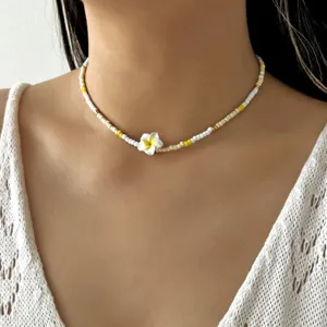 Nahaufnahme einer handgefertigten Perlenkette mit weißem Frangipani Blütenanhänger