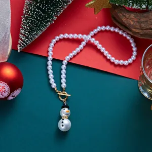 Collana di perle natalizia con ciondolo a pupazzo di neve e chiusura dorata fine.