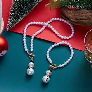 Set di gioielli di perle natalizie con collana e bracciale a pupazzo di neve in dettaglio.
