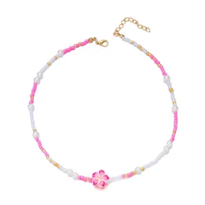 Detailansicht einer Perlenhalskette im Preppy-Stil mit rosa Blüte und bunten Keramikperlen.