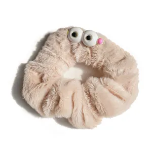 Cute plush monster eye scrunchie hair tie in soft beige for autumn winter style