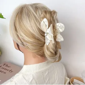 Elegant white bougainvillea acetate flower hair claw clip with rhinestone detail on blonde hair.