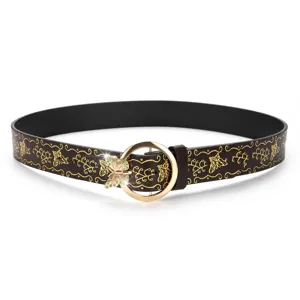 Detailed view of brown leather belt with gold butterfly patterns and green rhinestone buckle