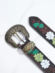 Close-up of Bohemian style belt with engraved metal buckle and floral pattern
