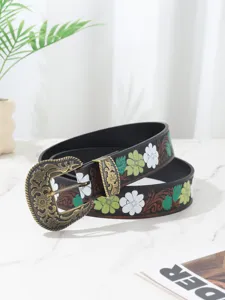 Close-up of Bohemian floral leather belt featuring an ornate antique brass buckle