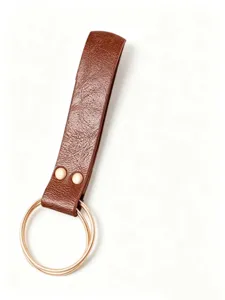 Detailed view of brown steampunk leather belt loop accessory with dual golden rings