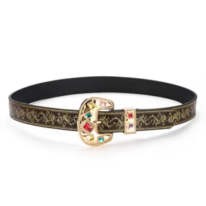 Close-up of vintage Western cowboy belt with gold embossing and gemstone buckle