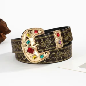 Detail of vintage western cowboy belt with embossed pattern and gemstone buckle