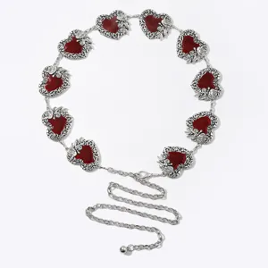 Elegante cintura a catena in metallo argento con ciondoli a cuore rossi e dettagli floreali.