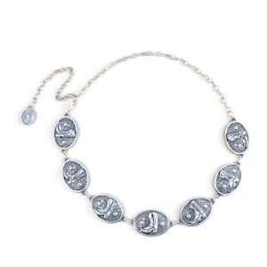 Cintura a catena in metallo argento con placche ovali a rilievo stile western.