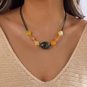 Detailansicht einer Vintage-Boho-Halskette mit unregelmäßigen bunten Acrylperlen am Modell.