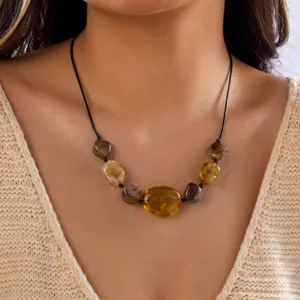 Nahaufnahme einer böhmischen Kette mit bernsteinfarbenen Acrylperlen an einem Modell.