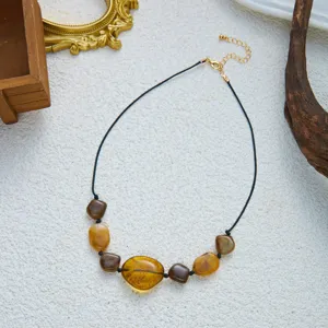 Nahaufnahme einer Vintage-Boho-Halskette mit unregelmäßigen Bernstein-Acrylperlen