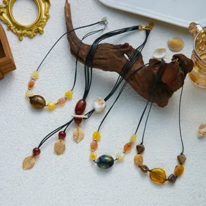 Detailansicht einer Sammlung böhmischer Halsketten mit Acrylperlen und Blattanhängern.