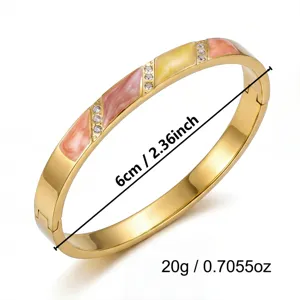 Detailweergave van een goudkleurige armband met roze en geel emaille, 6 cm diameter