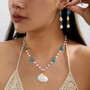 Dettaglio di collana e orecchini di perle stile spiaggia con ciondoli a stella e conchiglia