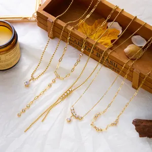 Close-up of assorted gold-tone stainless steel necklaces featuring sparkling zirconia stones.