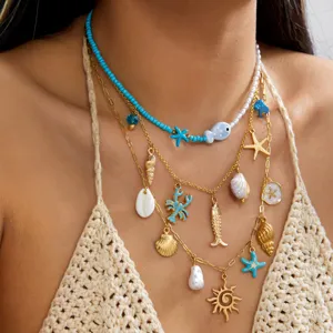 Primo piano di una collana a strati a tema marino con stelle marine e ciondoli a forma di pesci.