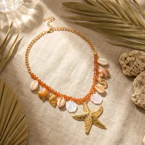 Dettaglio di una collana a tema marino con stella marina, conchiglie e perline