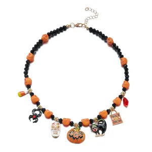 Detailed view of a Halloween charm necklace with pumpkin, cat, and skull pendants.