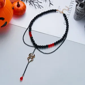 Detailed macro view of Halloween spider pendant necklace with black beads and red crystals