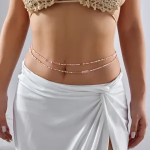 Close-up detail of a bohemian multi-layer pink and white beaded waist chain on a model's waist