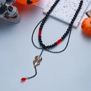 Detailed shot of a gothic Halloween spider necklace with black beads and red crystal accents.